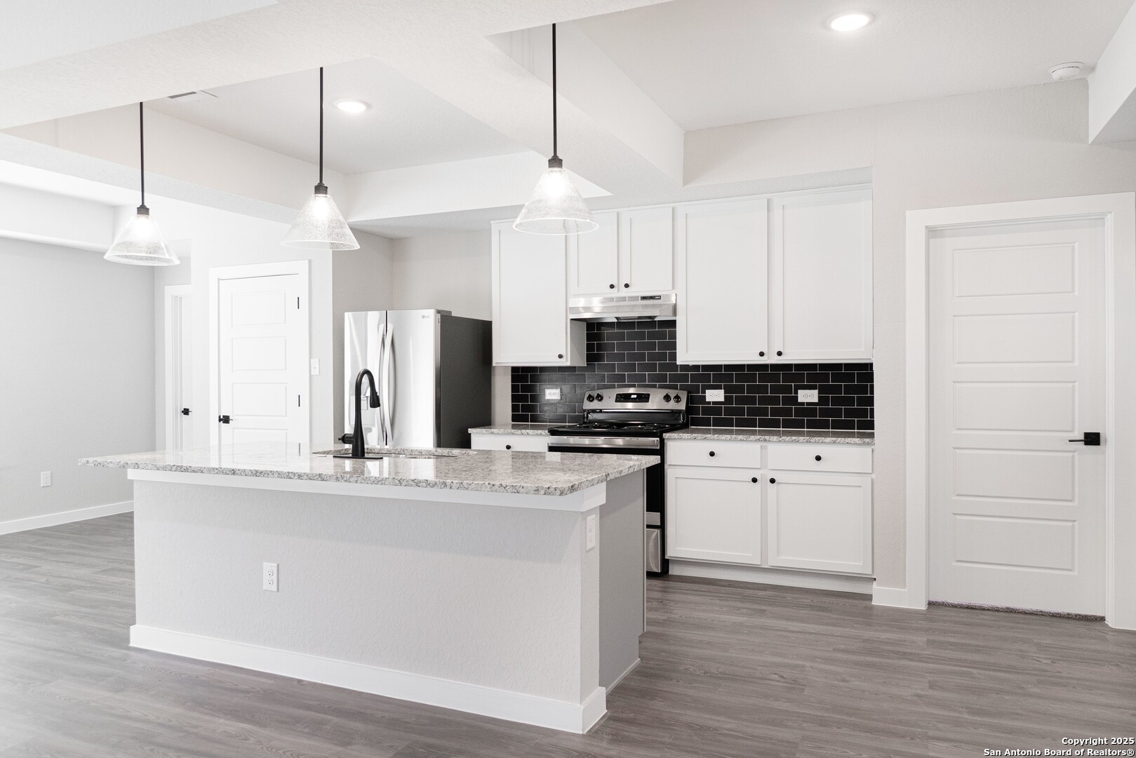 5815 Tree View Street San Antonio, TX 78220 - Photo 8 of 29 a kitchen with stainless steel appliances granite countertop a sink a stove and white cabinets with wooden floor