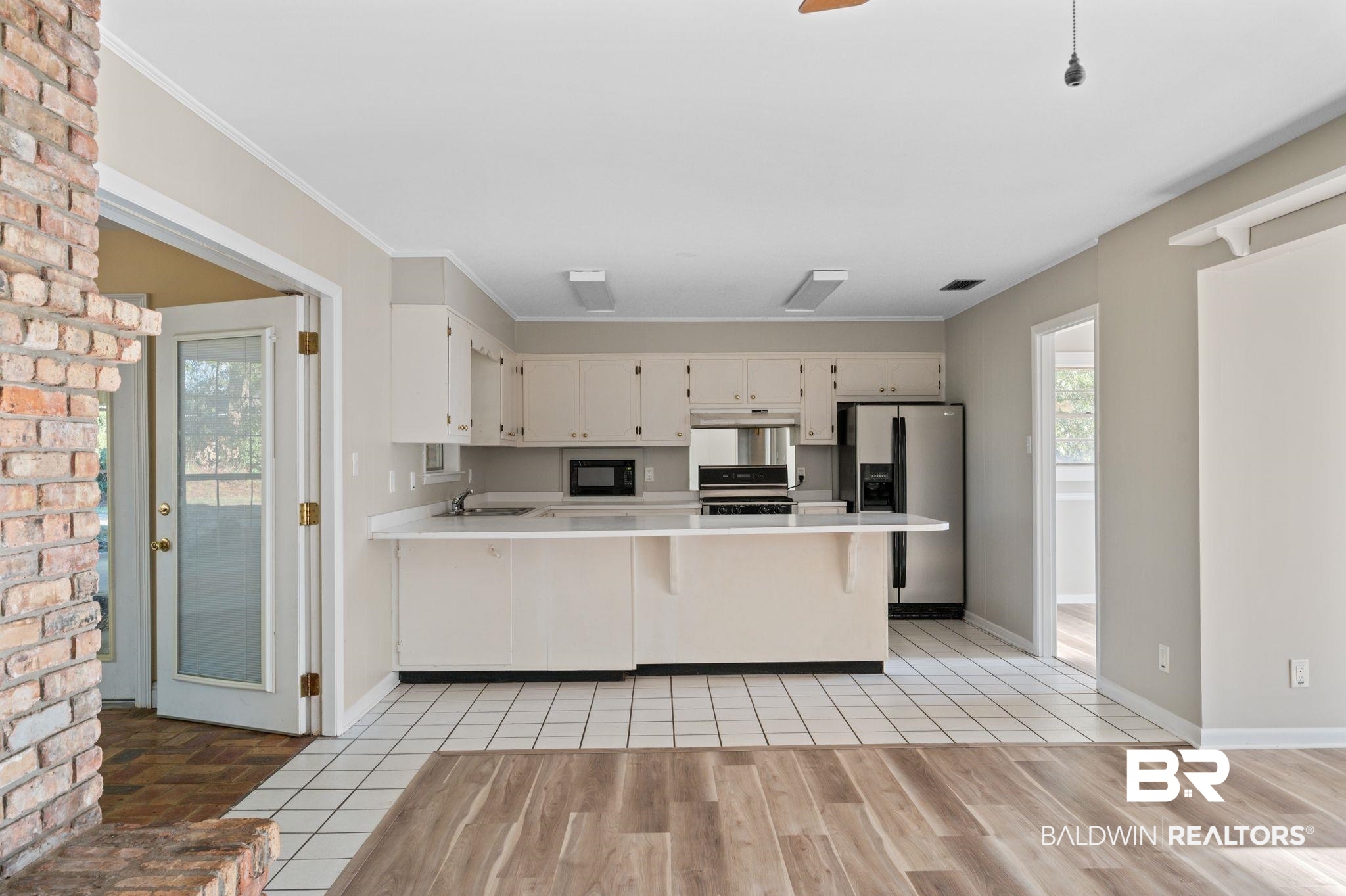 909 Caroline Avenue Daphne, AL 36526 - Photo 22 of 46 Kitchen with kitchen peninsula, stainless steel appliances, white cabinets, and sink