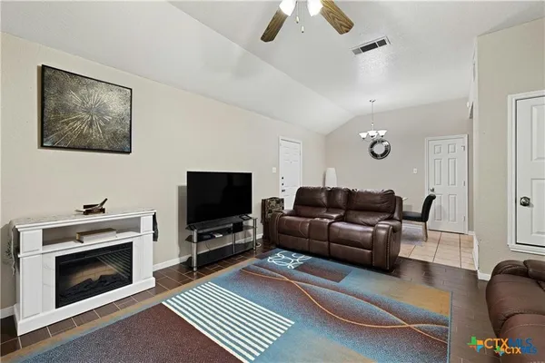 a living room with furniture a flat screen tv and a fireplace