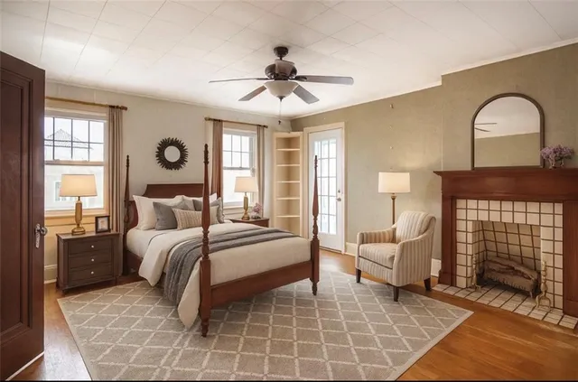 an empty room with wooden floor chandelier fan and windows