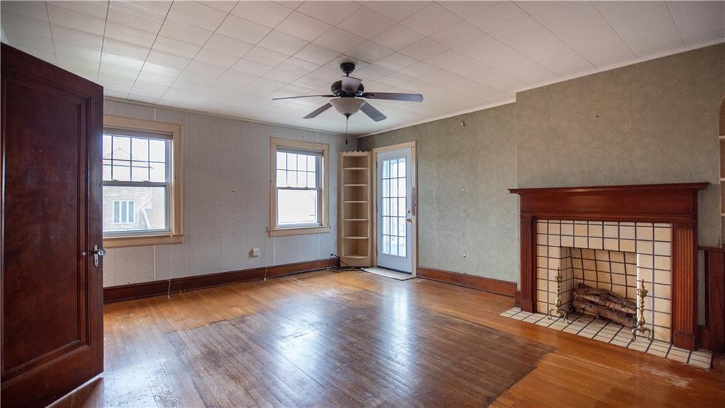 343 East 11th Avenue Tarentum, PA 15084 - Photo 29 of 41 an empty room with wooden floor chandelier fan and windows