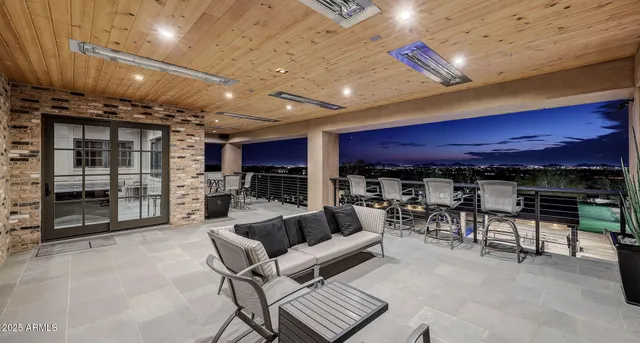 a dining hall with stainless steel appliances kitchen island granite countertop a table chairs and a view of living room