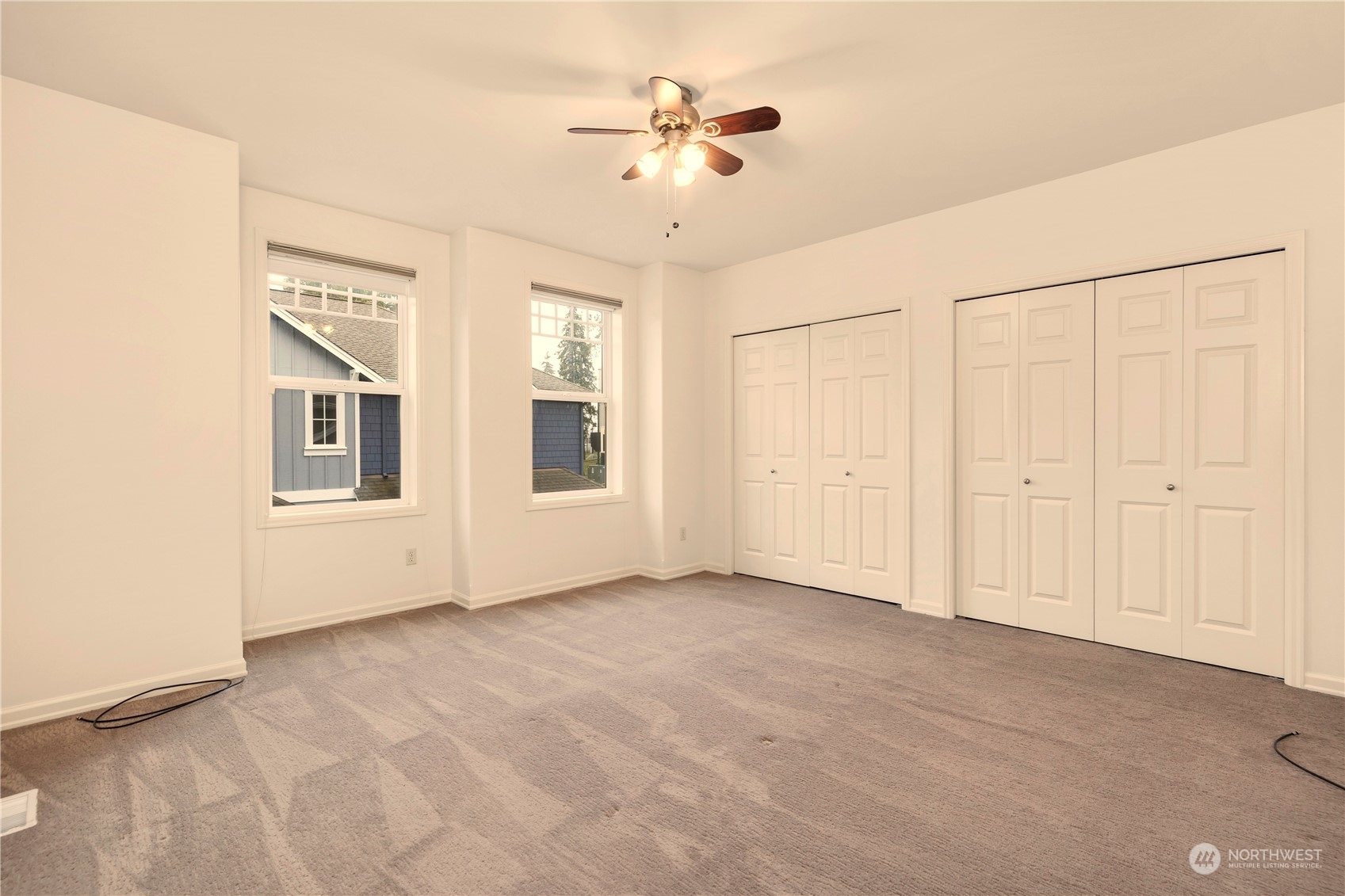 8507 Bowdoin Way, Unit 2 Edmonds, WA 98026 - Photo 19 of 24 an empty room with chandelier fan and windows