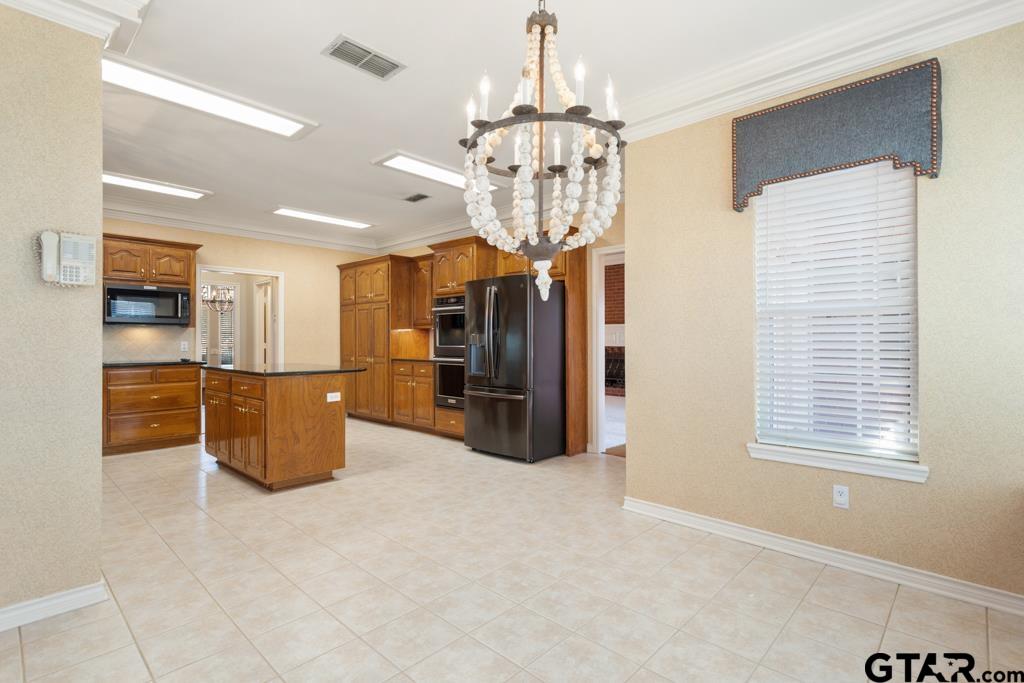 3103 Lakepine Circle Tyler, TX 75707 - Photo 20 of 48 a room with kitchen island stainless steel appliances furniture a chandelier and window