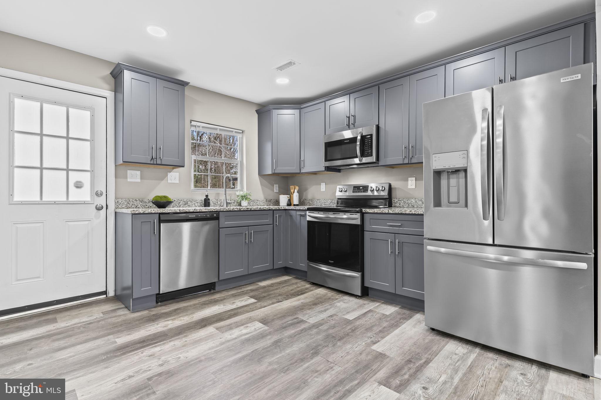 38461 Chaptico Road Mechanicsville, MD 20659 - Photo 8 of 35 a kitchen with stainless steel appliances granite countertop a refrigerator sink and microwave