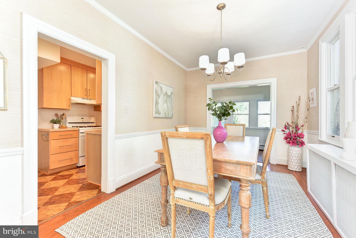 4427 Garrison Street Northwest Washington, DC 20016 - Photo 6 of 27 a dining room with wooden floor a chandelier a wooden table and chairs