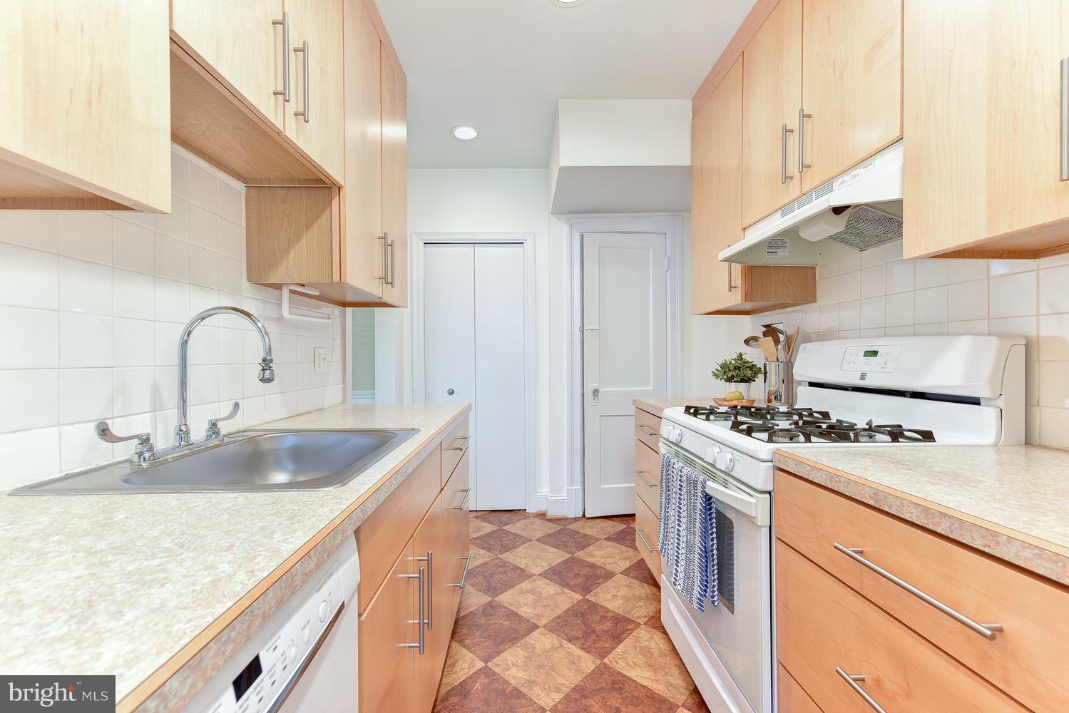 4427 Garrison Street Northwest Washington, DC 20016 - Photo 9 of 27 a kitchen with stainless steel appliances granite countertop a sink stove and refrigerator