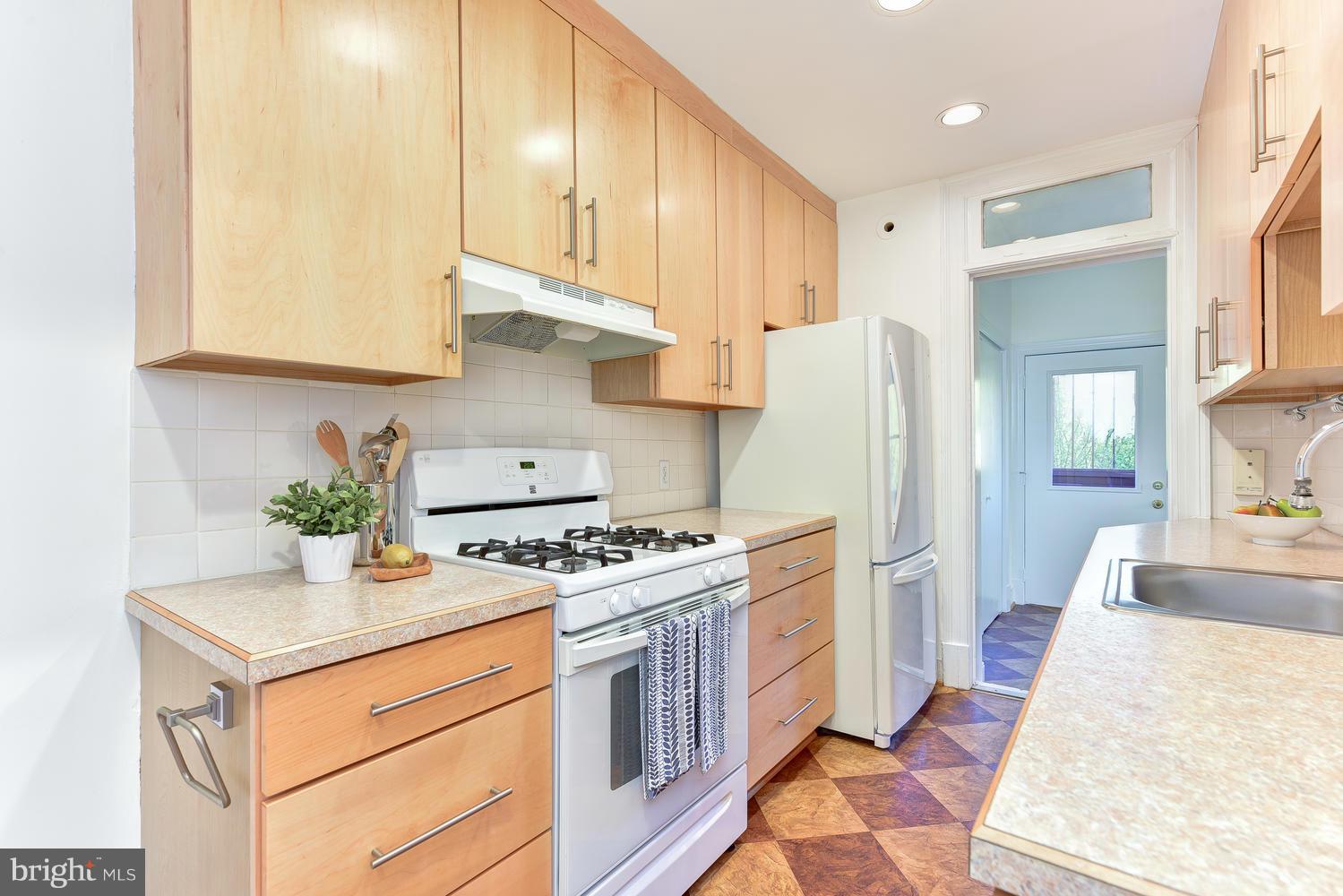 4427 Garrison Street Northwest Washington, DC 20016 - Photo 10 of 27 a kitchen with stainless steel appliances white cabinets and a stove top oven