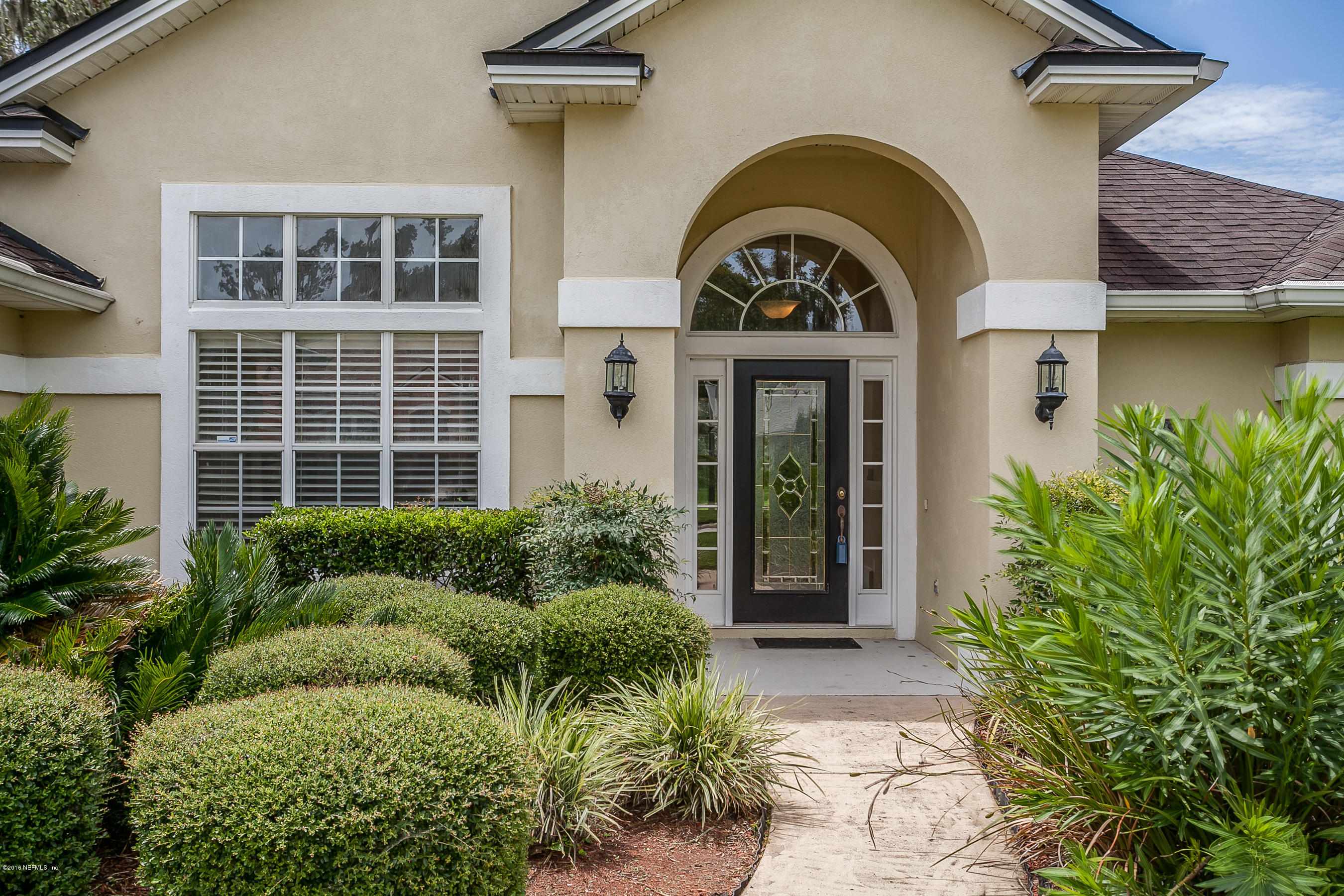 1727 Margarets Walk Road Fleming Island, FL 32003 - Photo 2 of 53 a view of a brick house with potted plants and a table and plants