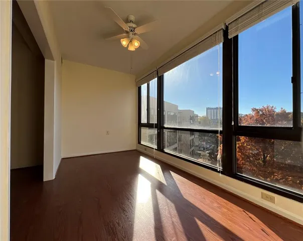 an empty room with wooden floor & closet area
