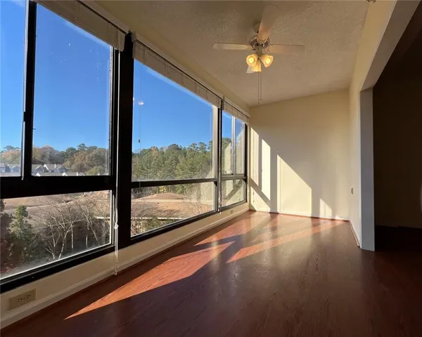 a view of an empty room with wooden floor