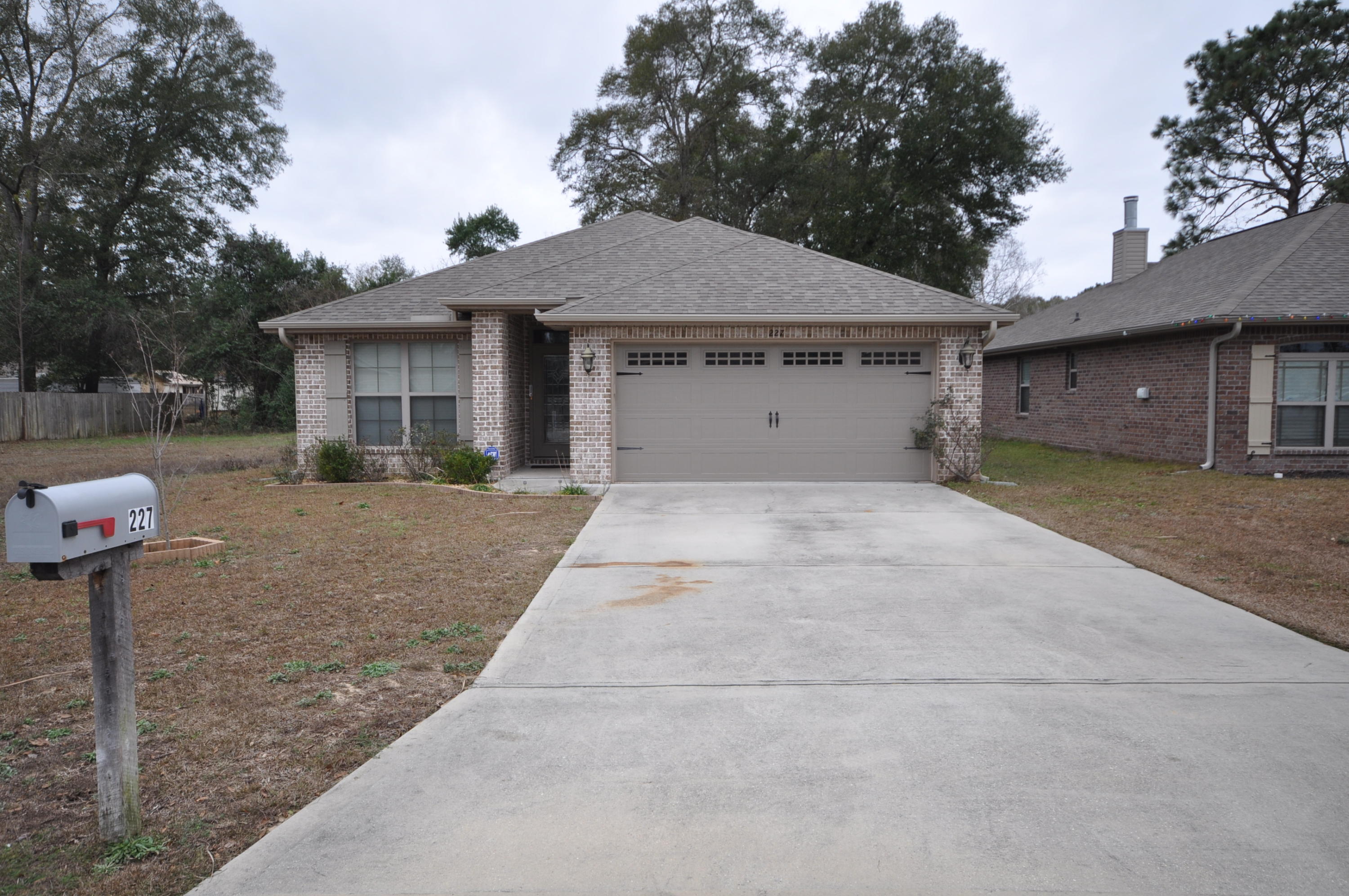 227 January Court Crestview, FL 32539 - Photo 2 of 20 a front view of a house with a yard and garage