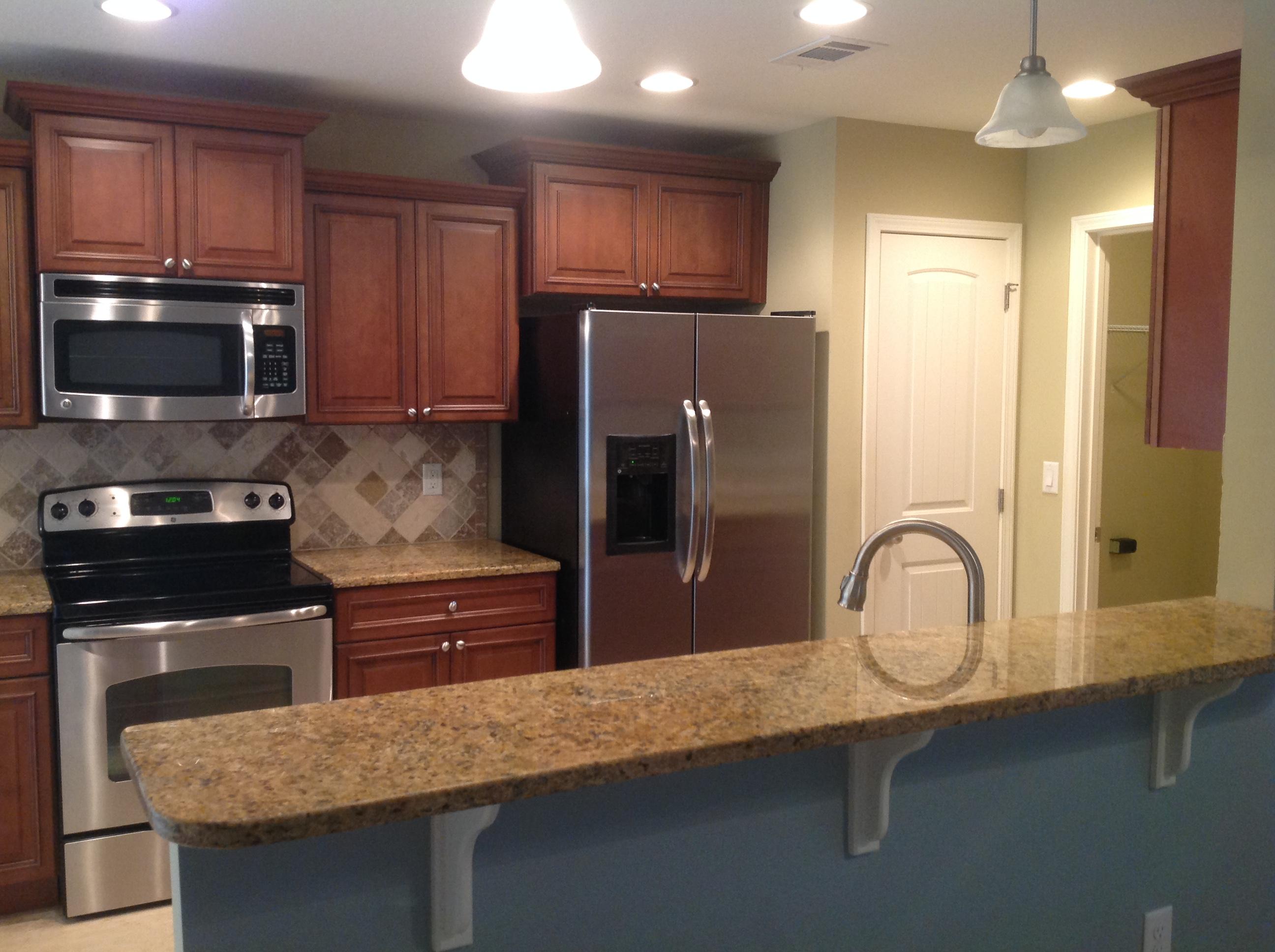 227 January Court Crestview, FL 32539 - Photo 9 of 20 a kitchen with granite countertop wooden cabinets and stainless steel appliances