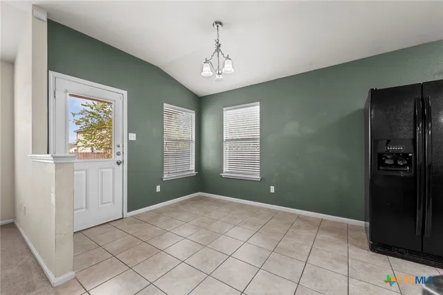 a view of an empty room with window and cabinet