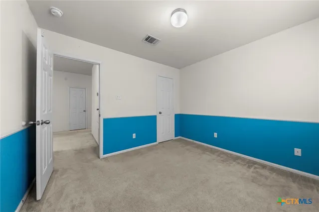 an empty room with closet and windows