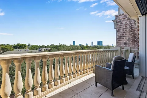 a view of roof deck with chairs and wooden fence
