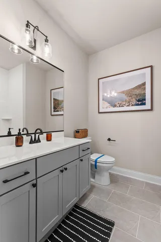 a spacious bathroom with a toilet a sink and mirror