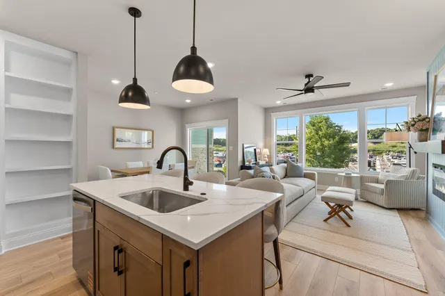 a view of living room kitchen with a sink and chandelier