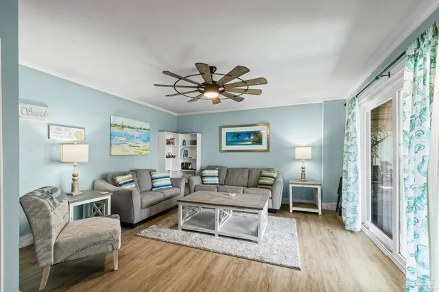 a living room with furniture a flat screen tv and a large window