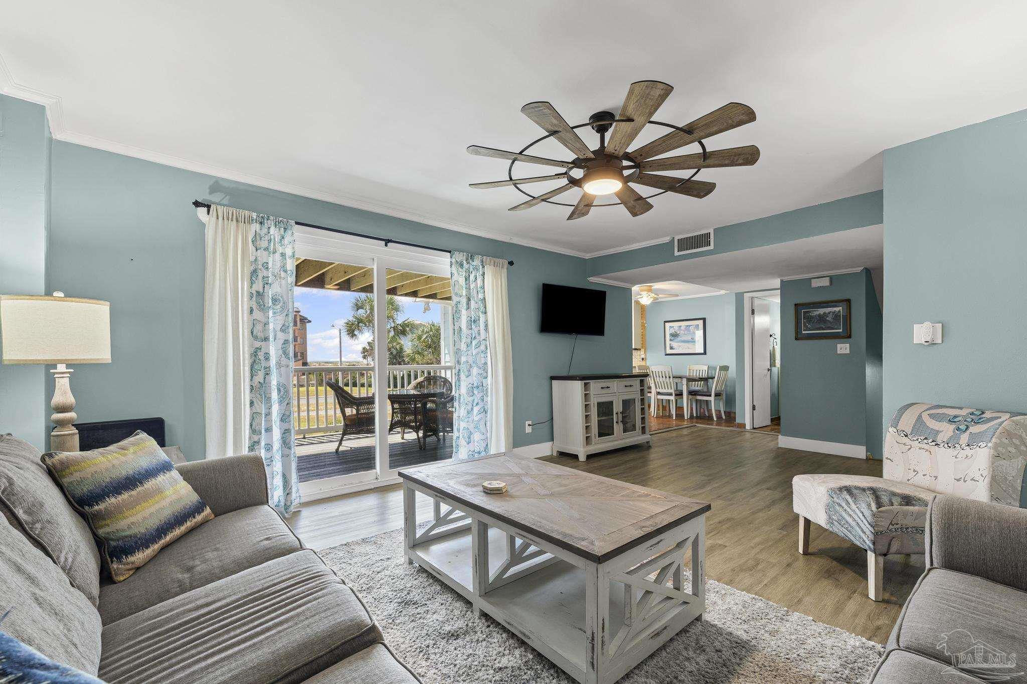 1100 Fort Pickens Road, Unit A13 Pensacola Beach, FL 32561 - Photo 15 of 63 a living room with furniture a flat screen tv and a large window