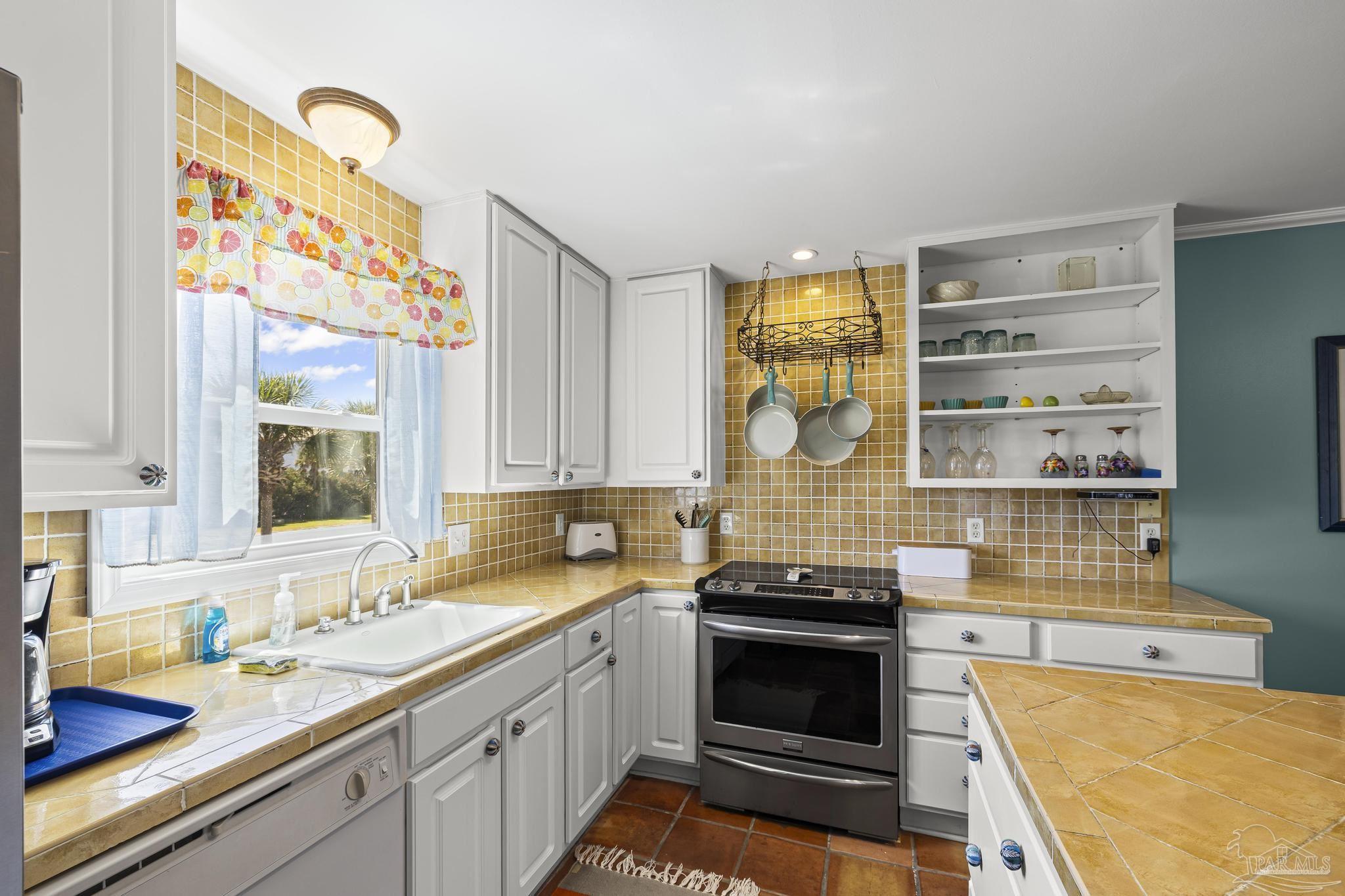 1100 Fort Pickens Road, Unit A13 Pensacola Beach, FL 32561 - Photo 23 of 63 a kitchen with stainless steel appliances a stove a sink and a microwave