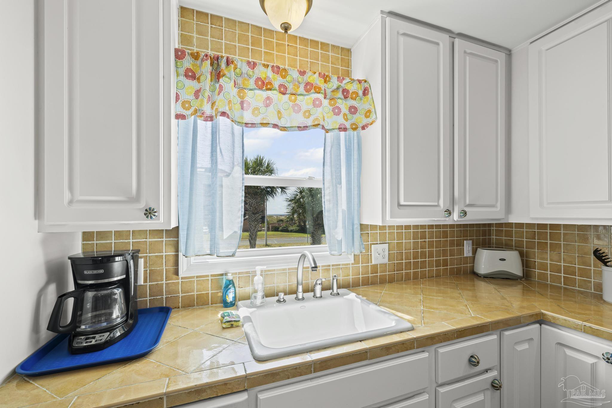 1100 Fort Pickens Road, Unit A13 Pensacola Beach, FL 32561 - Photo 24 of 63 a kitchen with a sink and cabinets