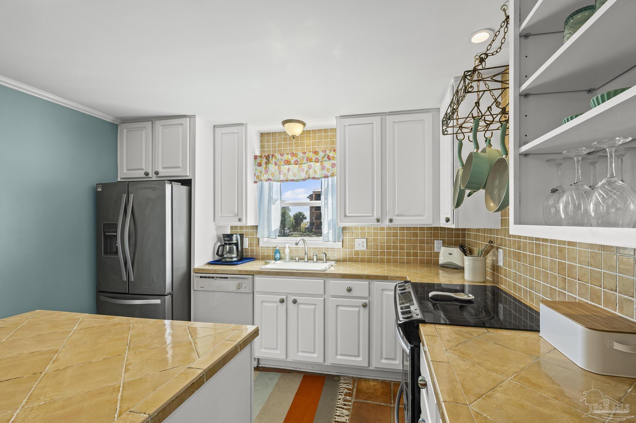 1100 Fort Pickens Road, Unit A13 Pensacola Beach, FL 32561 - Photo 26 of 63 a kitchen with stainless steel appliances a sink a stove a refrigerator and cabinets