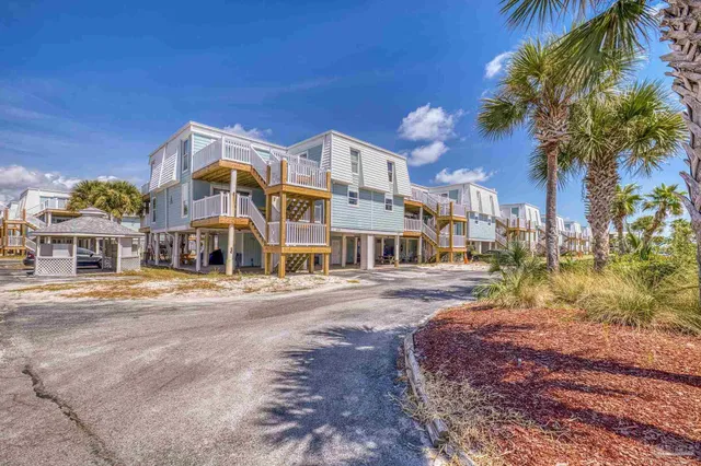 a view of a house with a big yard and large trees
