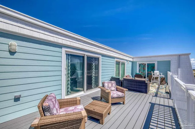 a view of a roof deck with table and chairs and wooden floor