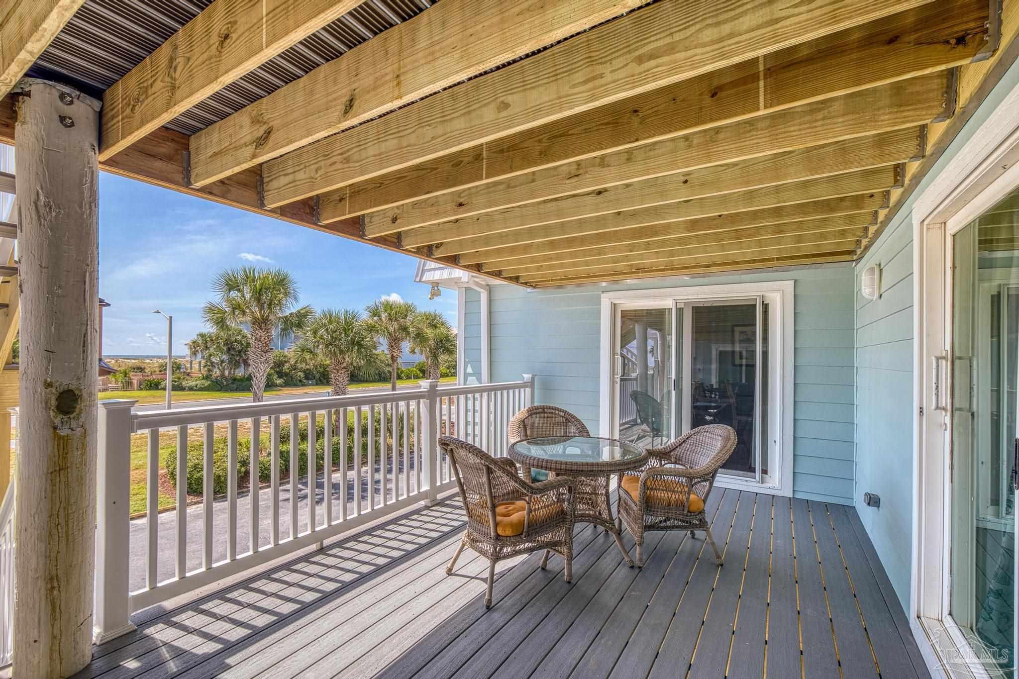 1100 Fort Pickens Road, Unit A13 Pensacola Beach, FL 32561 - Photo 43 of 63 a view of a roof deck with table and chairs and wooden floor