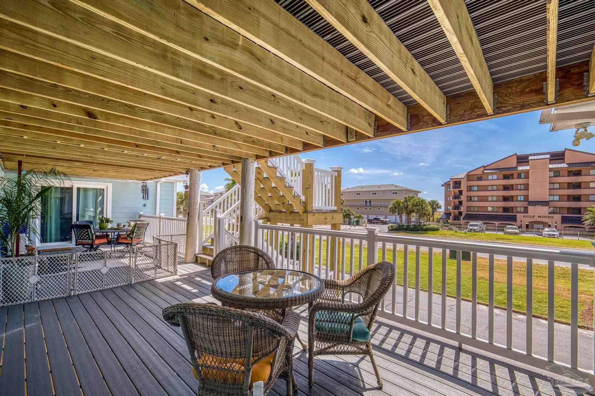 1100 Fort Pickens Road, Unit A13 Pensacola Beach, FL 32561 - Photo 45 of 63 a view of a roof deck with table and chairs and wooden floor