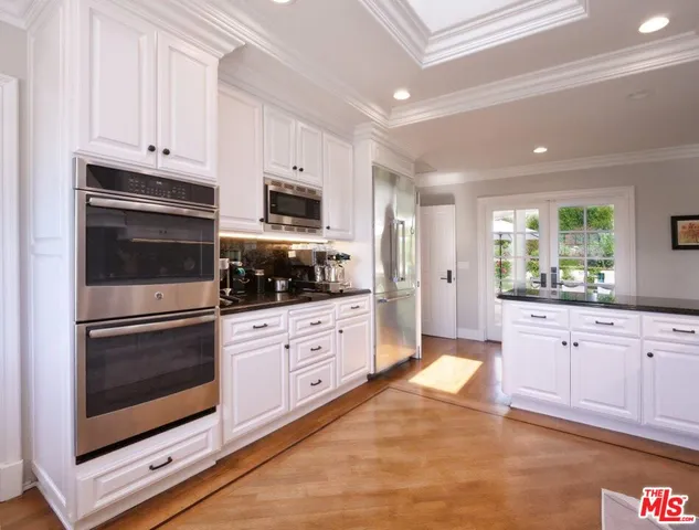 a kitchen with granite countertop white cabinets stainless steel appliances and a sink