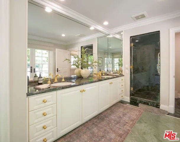 a bathroom with a double vanity sink toilet and shower