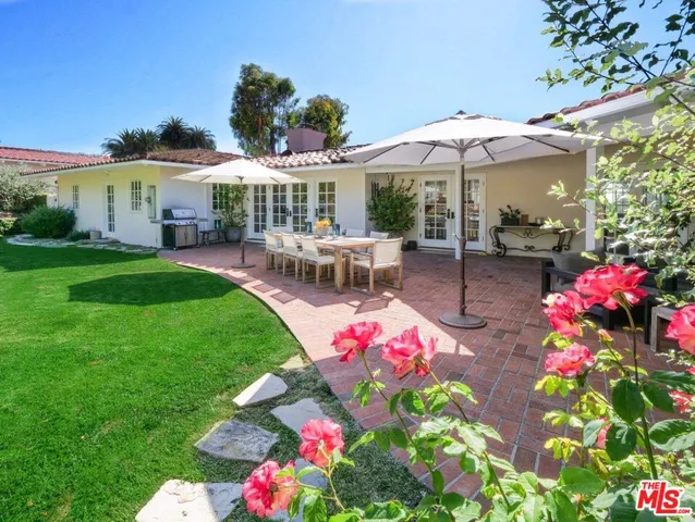 a patio with table and chairs under an umbrella