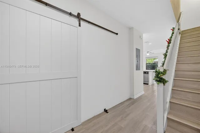 a view of a hallway with wooden floor and staircase