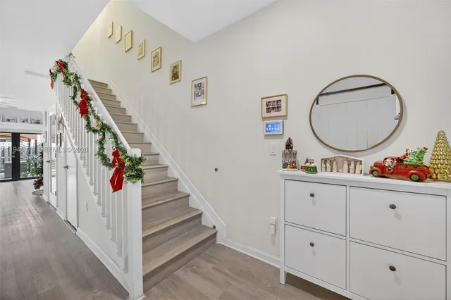 a view of a hallway with entryway wooden floor and front door