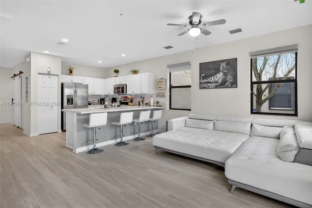 a living room with furniture and kitchen view
