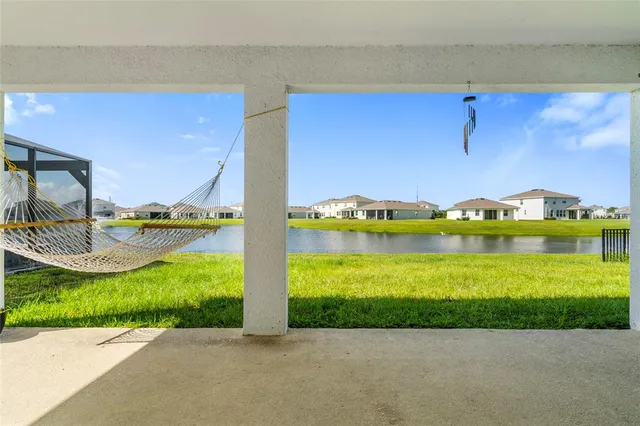 a front view of a house with a garden and lake view