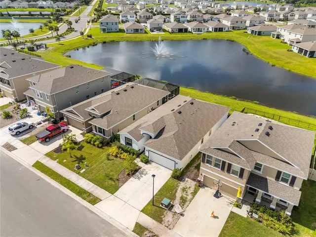 an aerial view of residential houses with outdoor space and lake view