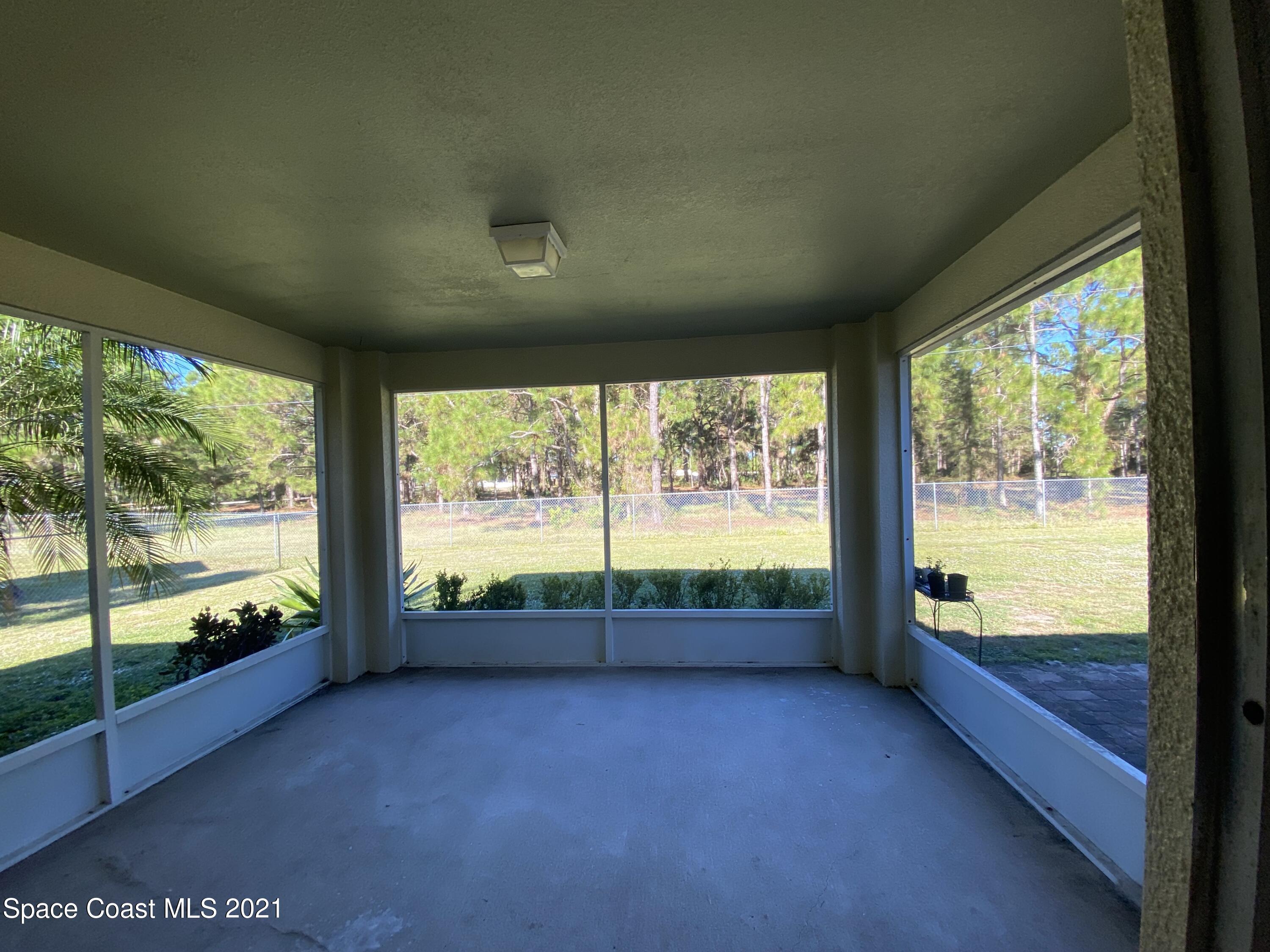 2481 Anchor Road Southeast Palm Bay, FL 32909 - Photo 11 of 32 a view of an empty room with wooden floor and a large window