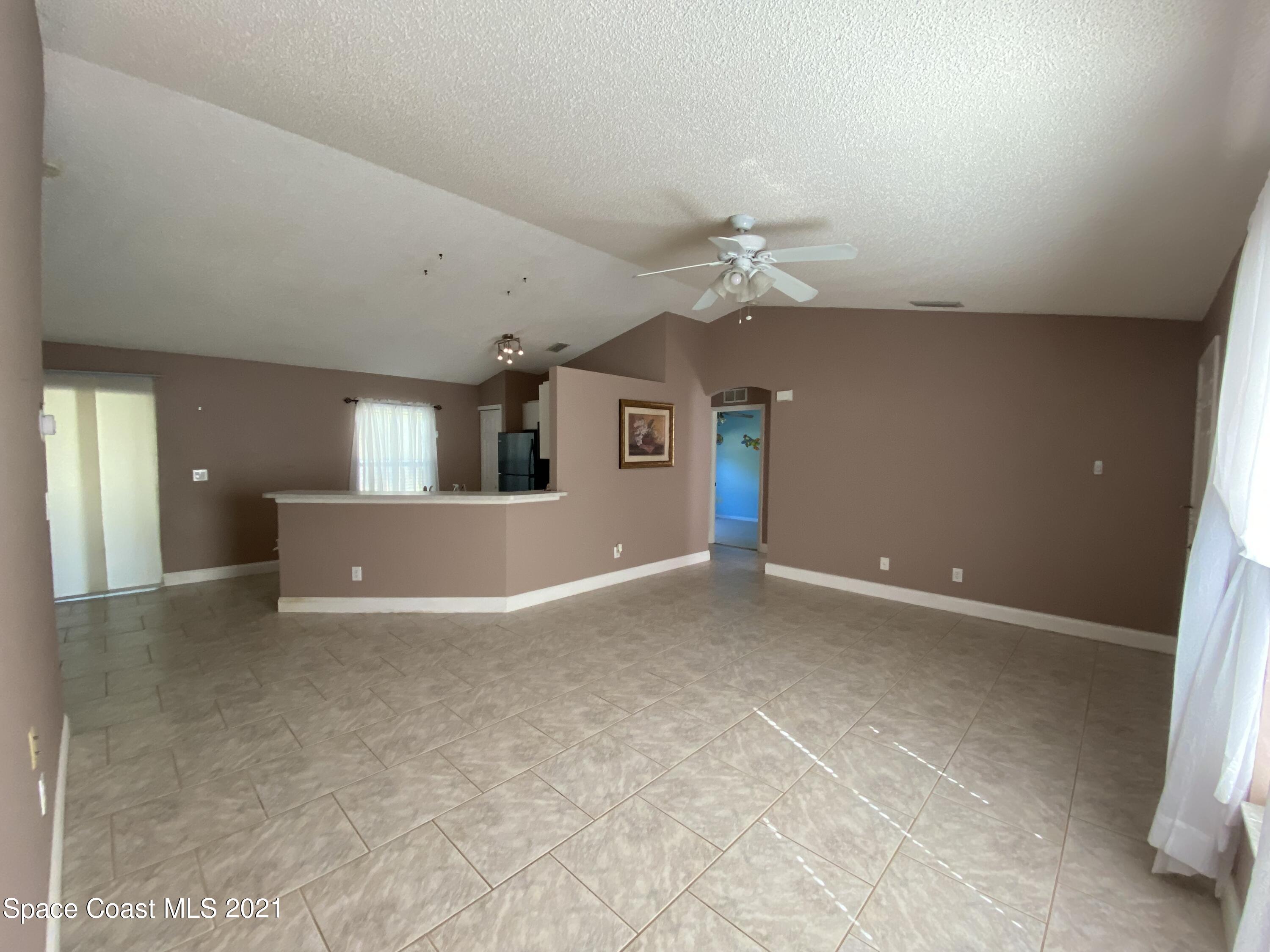 2481 Anchor Road Southeast Palm Bay, FL 32909 - Photo 15 of 32 an empty room with windows and fan