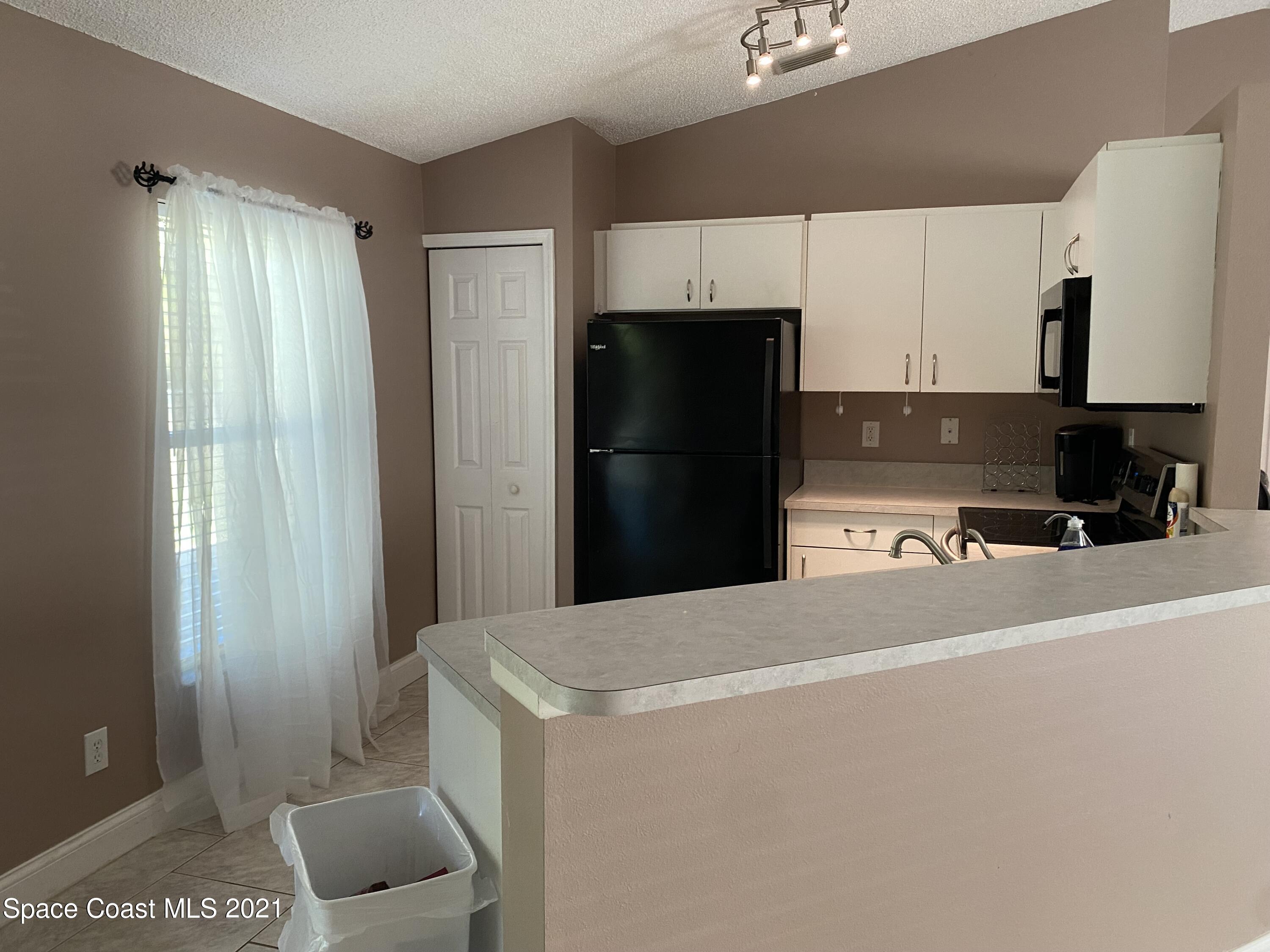 2481 Anchor Road Southeast Palm Bay, FL 32909 - Photo 16 of 32 a kitchen with a refrigerator and a sink