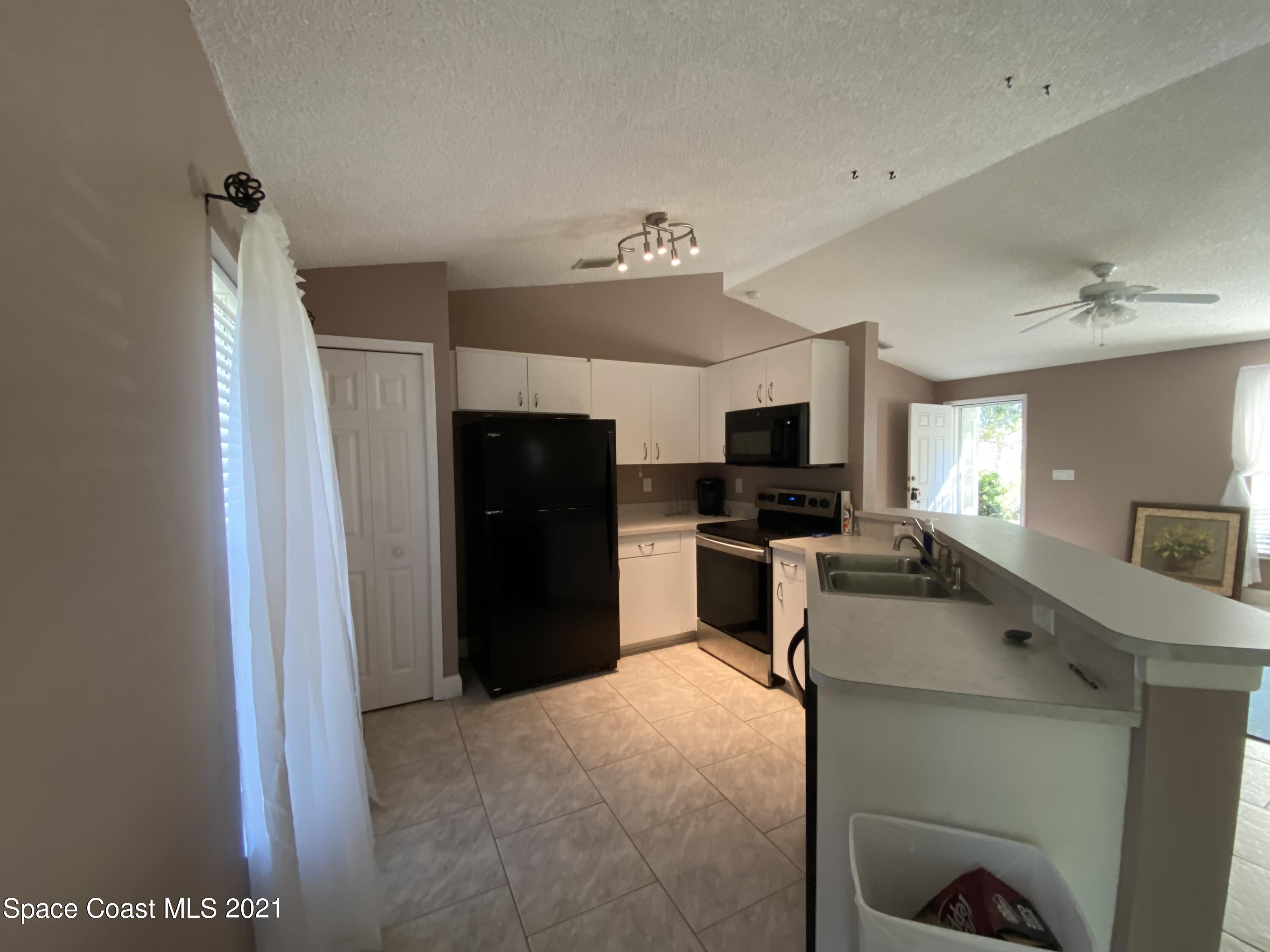 2481 Anchor Road Southeast Palm Bay, FL 32909 - Photo 17 of 32 a view of a kitchen with refrigerator and windows