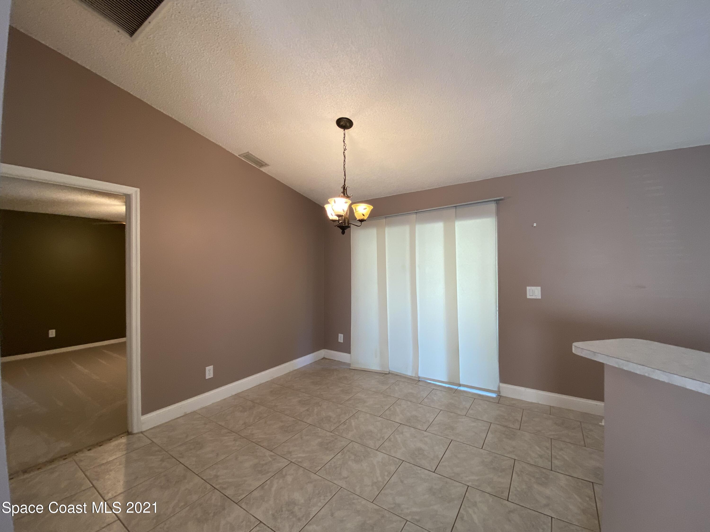 2481 Anchor Road Southeast Palm Bay, FL 32909 - Photo 19 of 32 a view of an empty room with window and chandelier fan