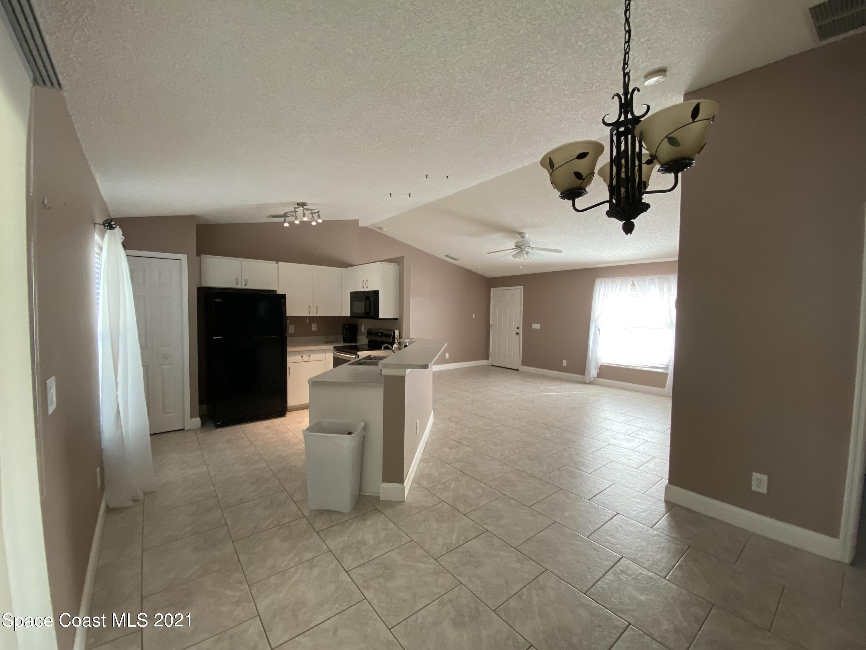 2481 Anchor Road Southeast Palm Bay, FL 32909 - Photo 20 of 32 a view of a kitchen with a sink and a refrigerator