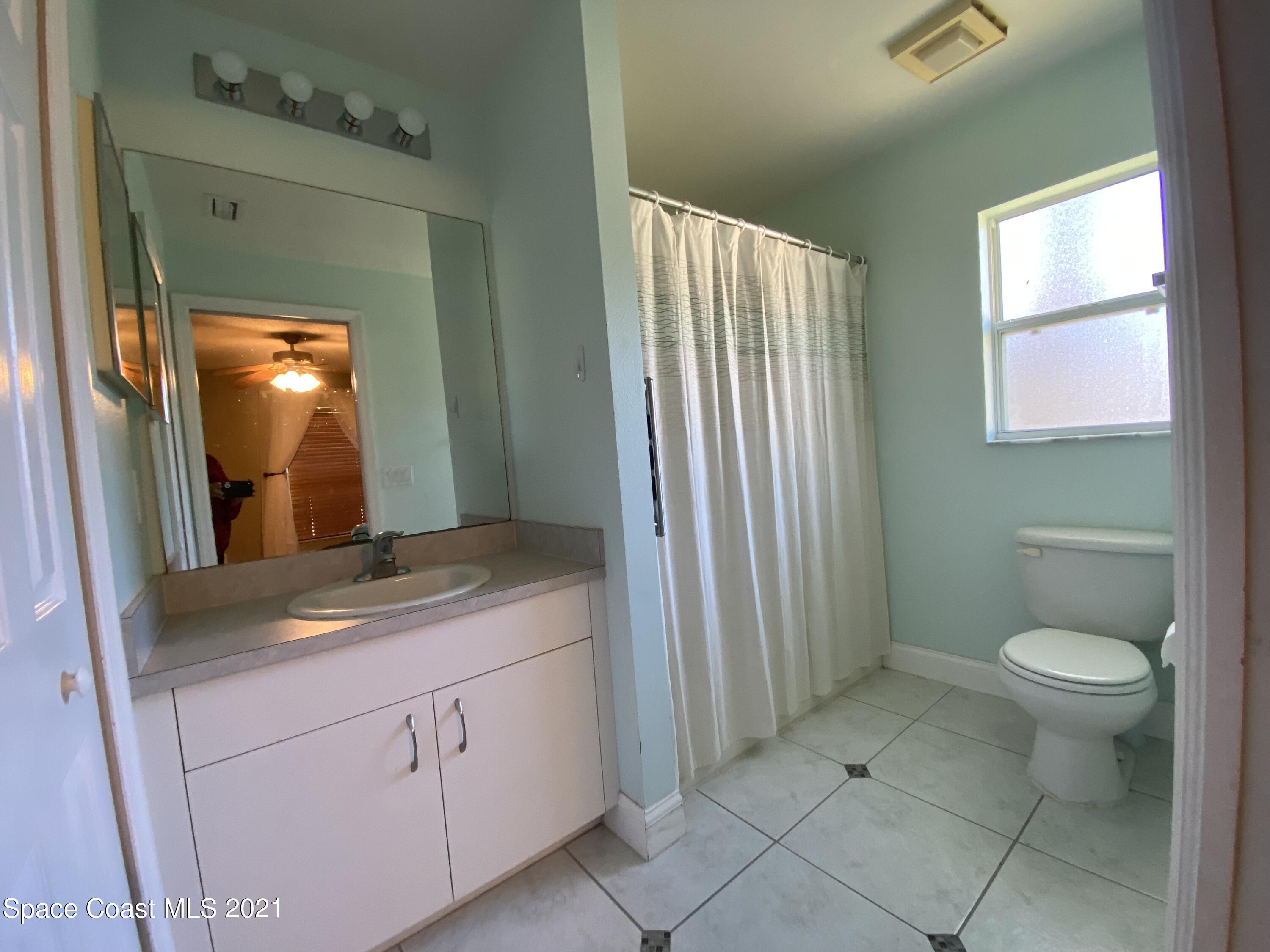 2481 Anchor Road Southeast Palm Bay, FL 32909 - Photo 25 of 32 a bathroom with a granite countertop sink toilet and mirror