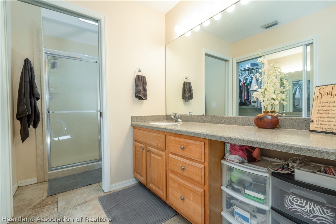 4021 Loquat Road Sebring, FL 33875 - Photo 13 of 26 a spacious bathroom with a granite countertop sink and a mirror