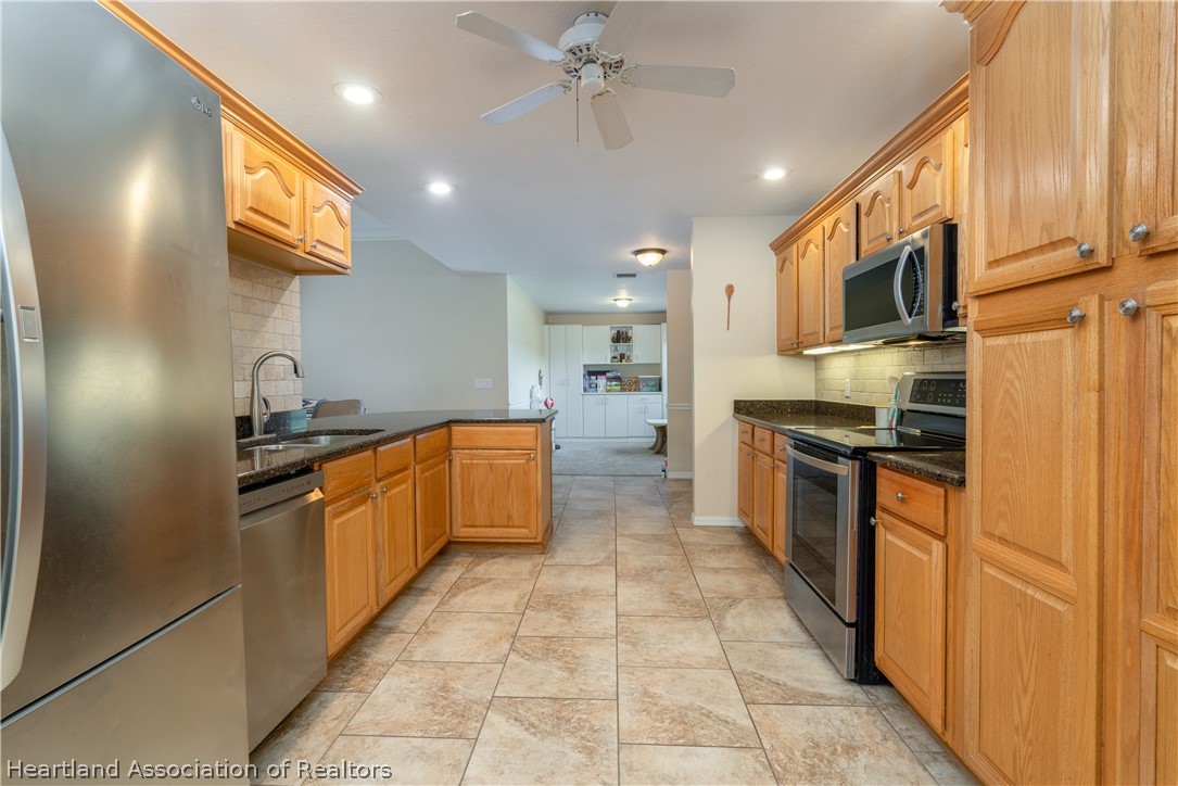 4021 Loquat Road Sebring, FL 33875 - Photo 7 of 26 a large kitchen with stainless steel appliances granite countertop a stove a sink and a refrigerator