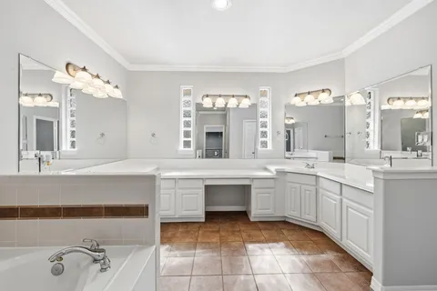 a large bathroom with a large tub sink and mirror