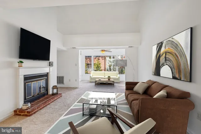 a living room with furniture a flat screen tv and a fireplace